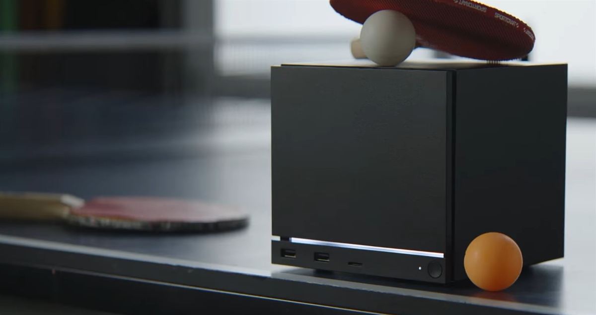 Futuristic Valve Steam Machine gaming console set in a modern living room with a 4K monitor.