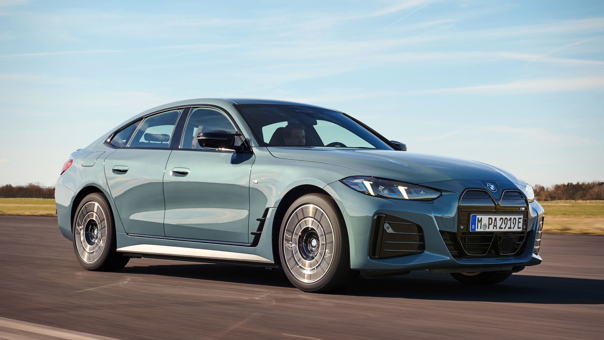 Image of a BMW i4 electric sedan in a futuristic showroom, highlighting design and technological innovation.